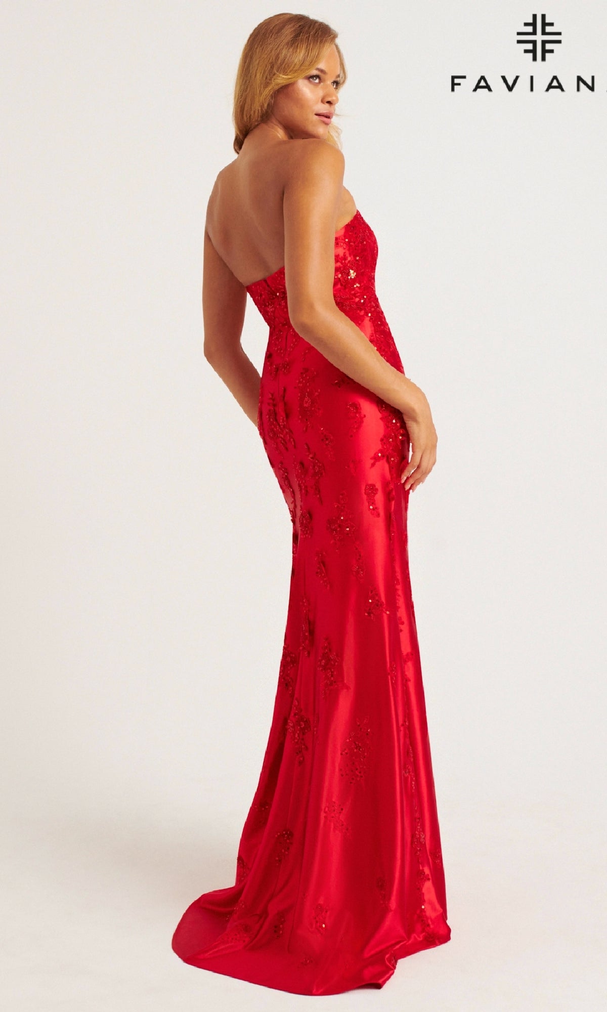 A woman models the Faviana 11228 Strapless Satin Prom Dress—floor-length, fitted, in red stretch satin with sequin details—against a plain backdrop. Faviana logo appears in the top right corner.